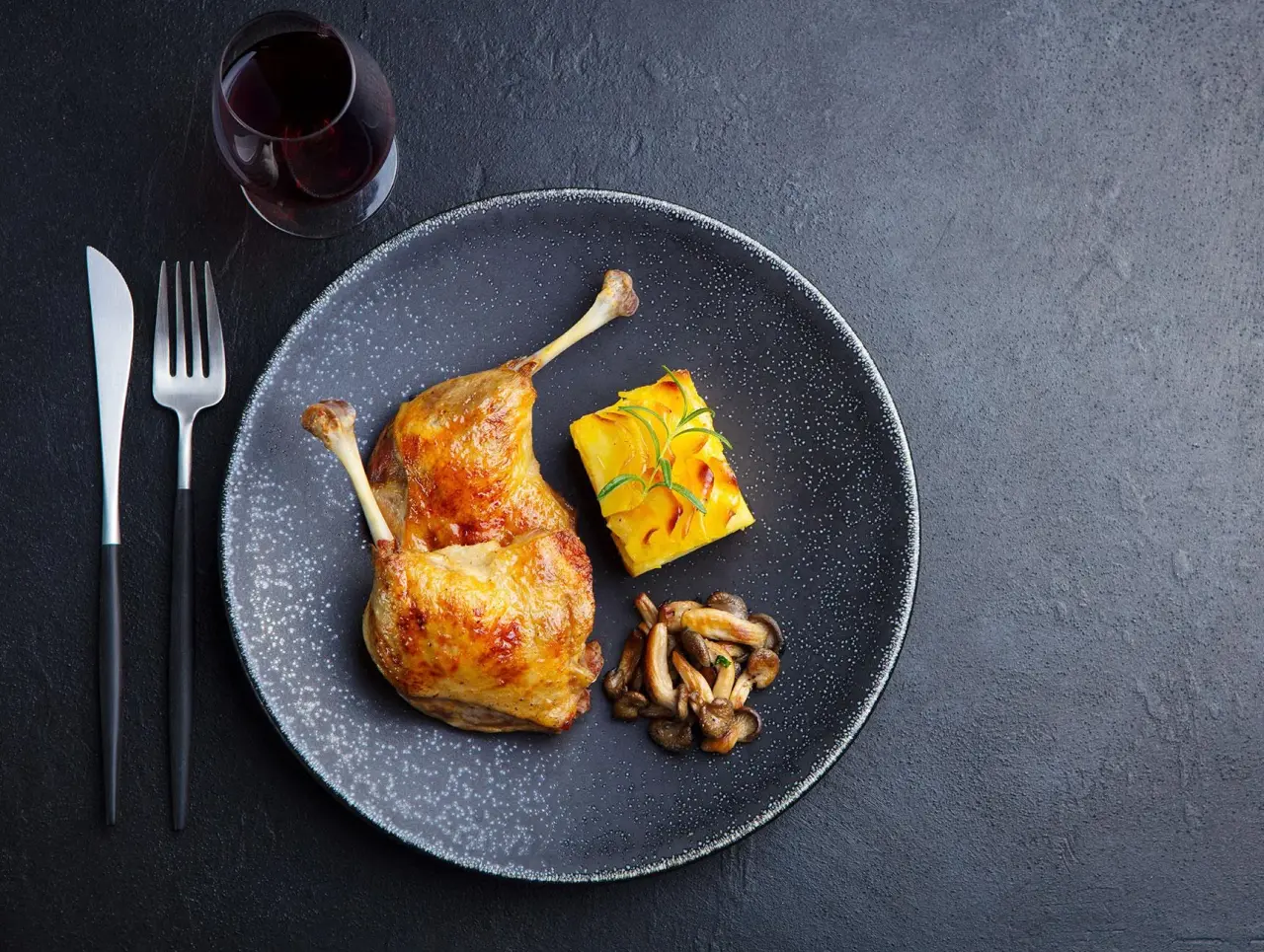 Gebratenes Entenbein mit Kartoffelgratin und Pilzen, serviert im Restaurant des Waldhaus Ohlenbach.