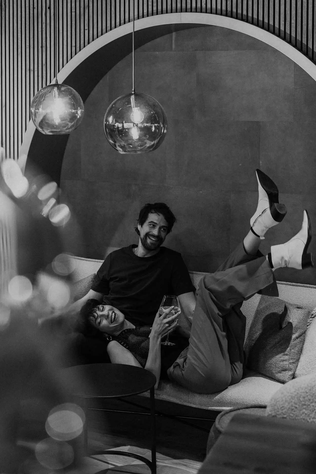 Entspanntes Paar genießt Drinks auf einem Sofa in der stilvollen Lounge des Hotel Steiner.