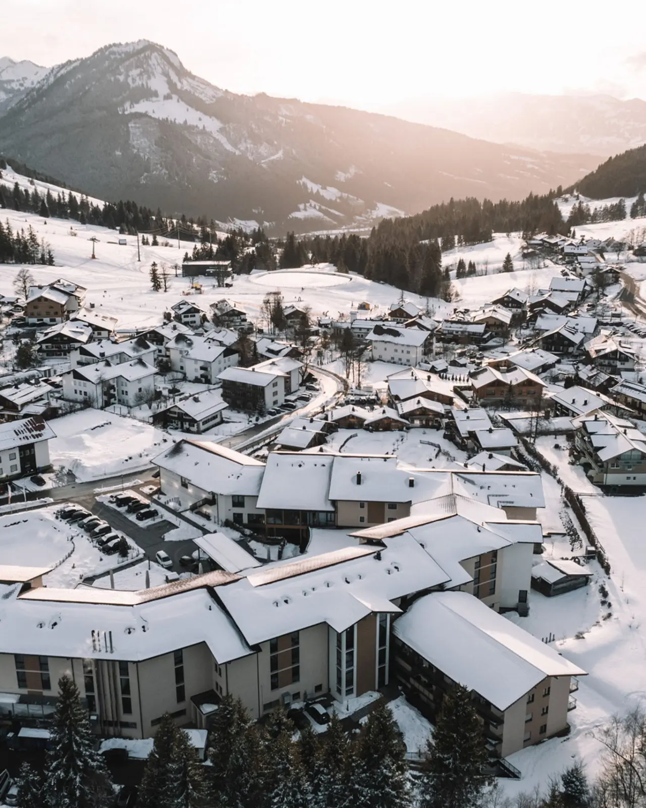 Winterliche Aussenansicht des Parkhotel Jordanbad in verschneiter Berglandschaft mit Abendsonne.