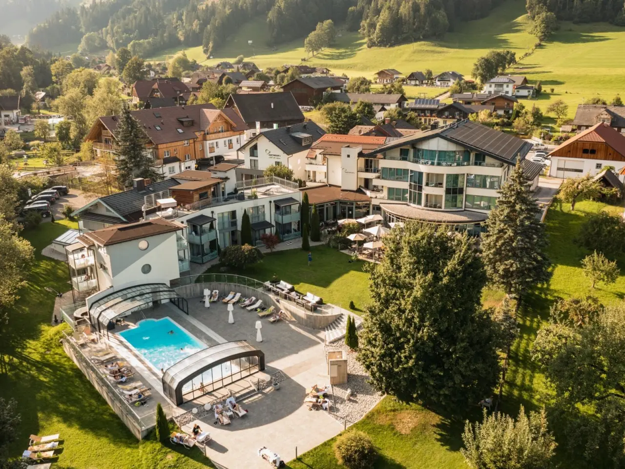 Luftaufnahme von Hartweger's Hotel in Weißenbach bei Schladming mit Außenpool, Sonnenterrasse und umliegender Natur.