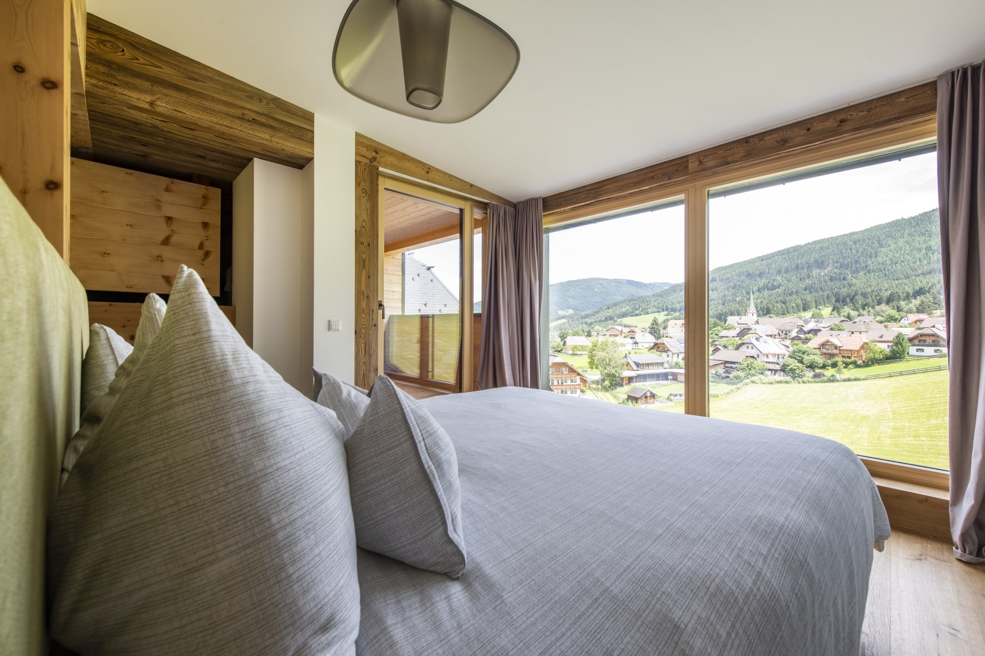 ALMGUT Mountain Wellness Hotel in St.Margarethen im Lungau – Gemütliches Hotelzimmer mit Blick auf das Dorf | Wellnesshotel Lungau