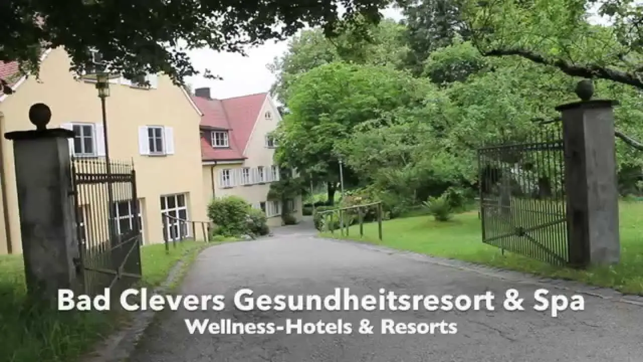 Eingangsbereich des Bad Clevers Gesundheitsresort & Spa mit Zufahrt und historischem Gebäude umgeben von Grün.