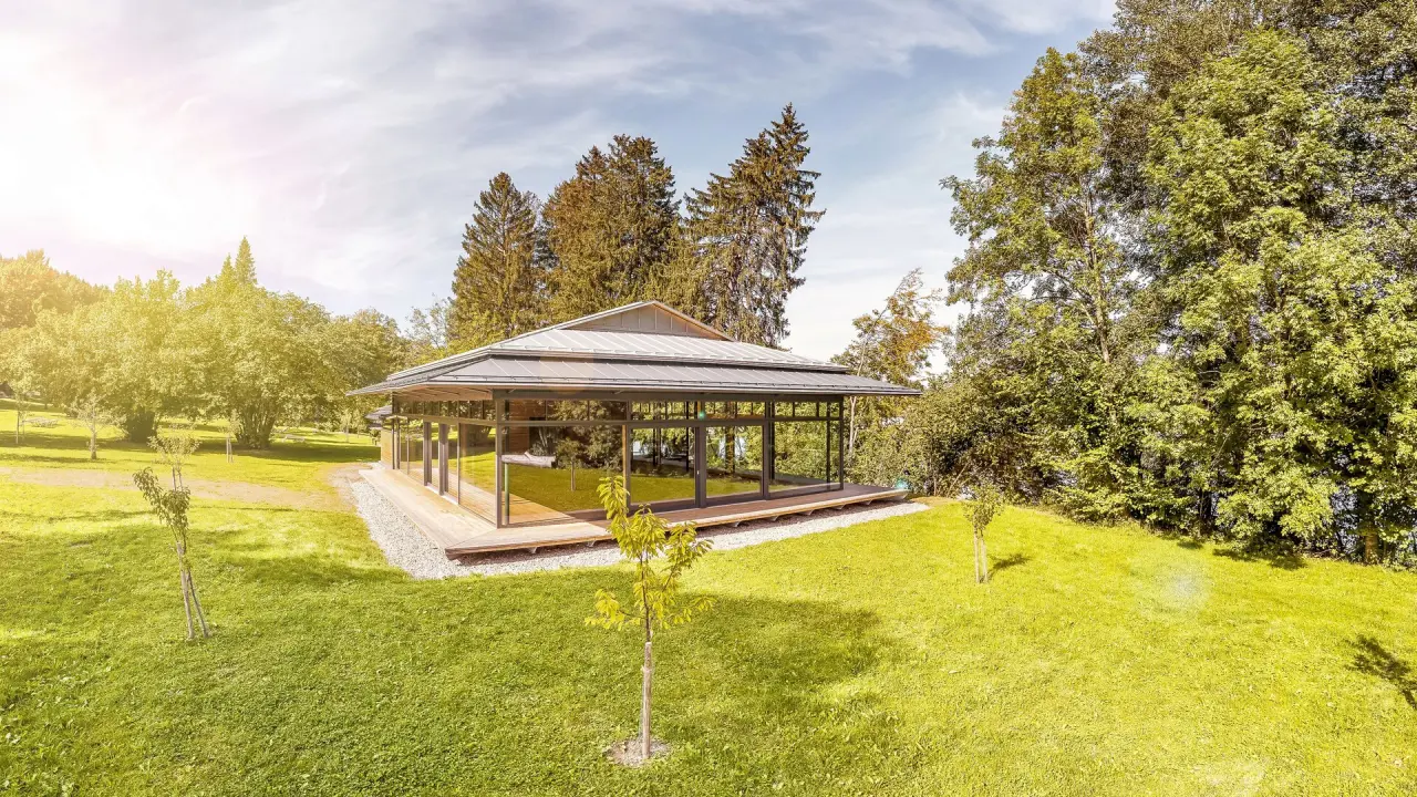 Moderner Glaspavillon umgeben von grüner Natur im Garten des Bad Clevers Gesundheitsresort & Spa.