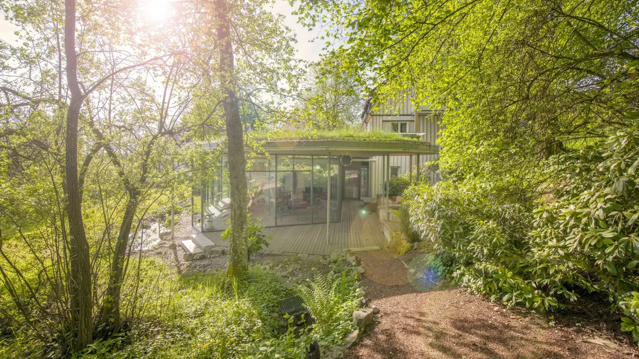 Bad Clevers Gesundheitsresort & Spa: Modernes Gebäude mit Glasfront und Gründach, eingebettet in grüne Natur und Bäume.