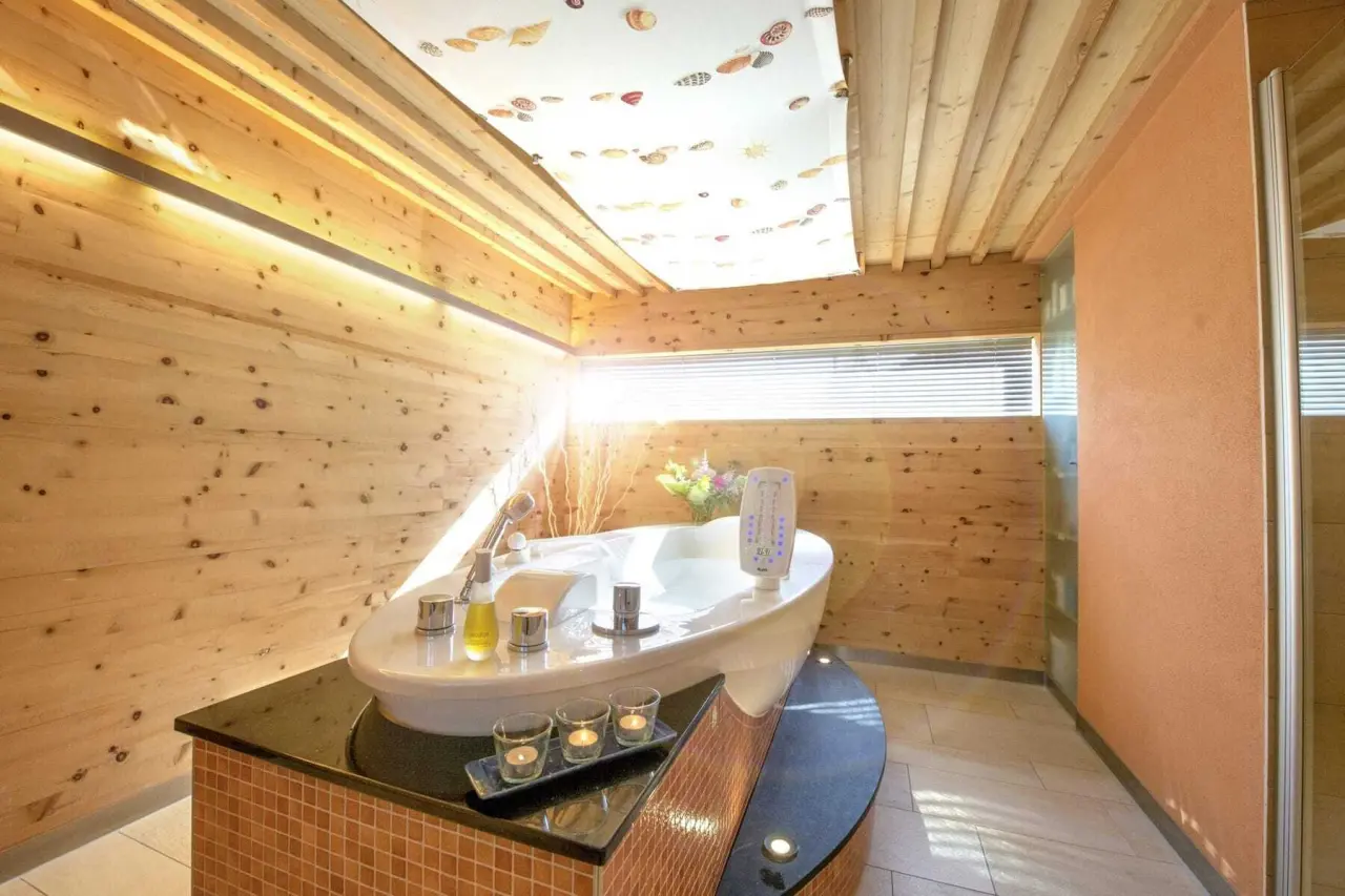 Moderne Badewanne mit Holzvertäfelung und Kerzen im Spa-Bereich des Bad Clevers Gesundheitsresort & Spa.