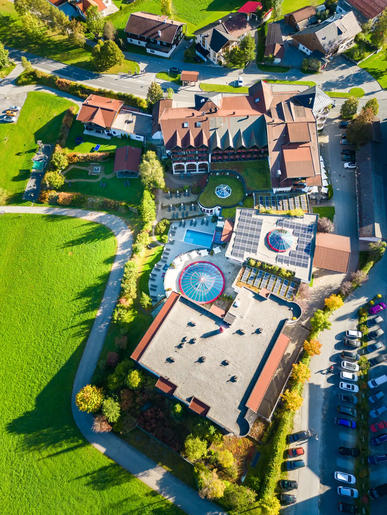 Luftaufnahme des Hotel Tyrol am Haldensee mit weitläufiger Anlage, Aussen- und Innenpools sowie grüner Landschaft.