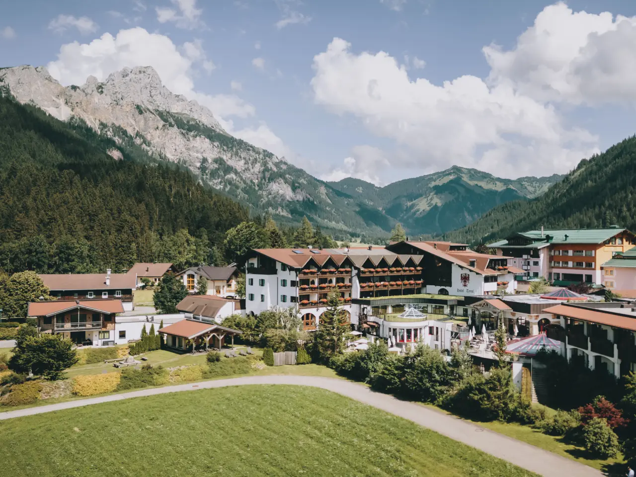 Panoramablick auf das Hotel Tyrol am Haldensee, eingebettet in die majestätische Berglandschaft der Tiroler Alpen.