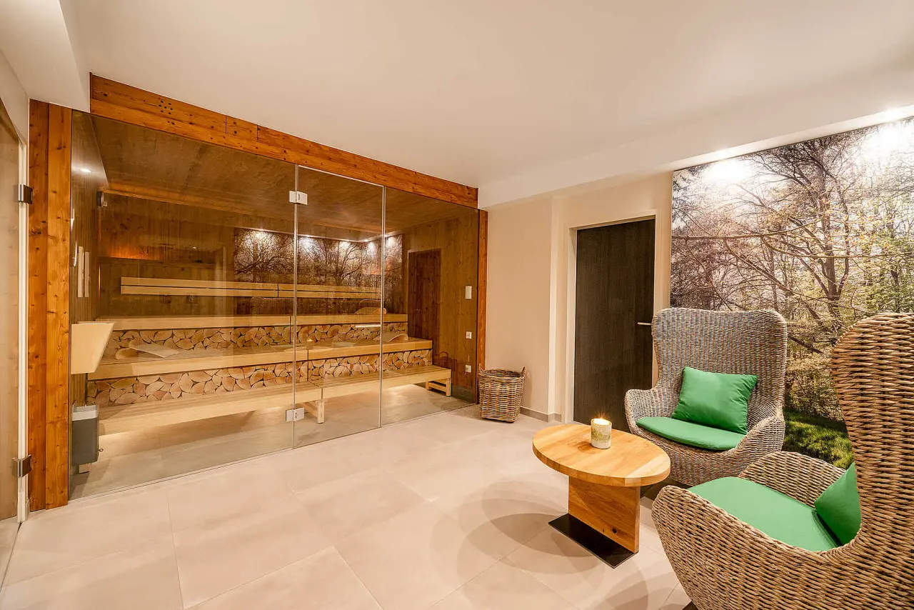 Moderne finnische Sauna mit Glasfront und gemütlichem Ruhebereich im Hotel Munte am Stadtwald.