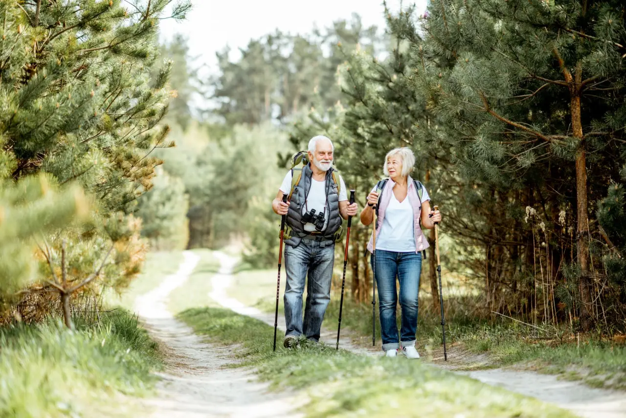 Älteres Paar beim Nordic Walking auf einem Waldweg in der Natur rund um Rüters Parkhotel.