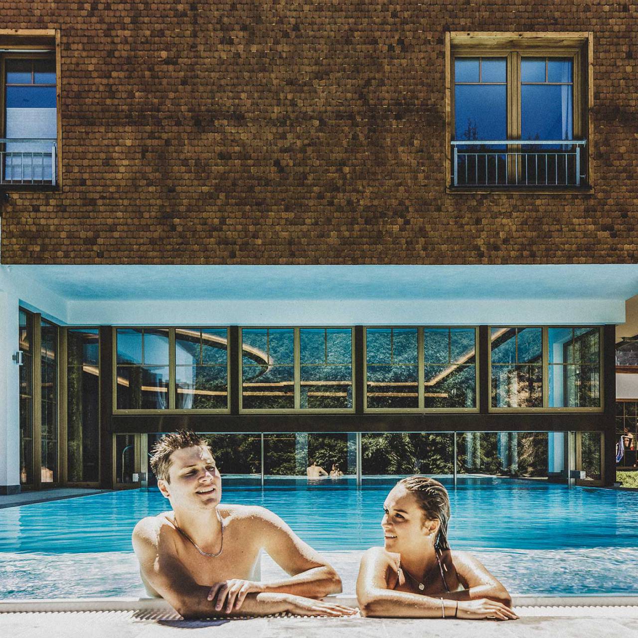 Hotel Forsthaus Auerhahn in Baiersbronn – Glückliches Paar im modernen Innen-Außenpool | Wellnesshotel Schwarzwald