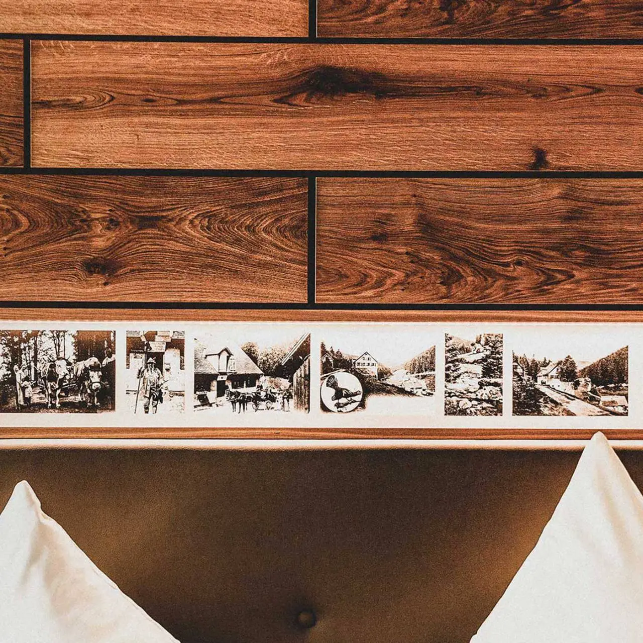 Hotel Forsthaus Auerhahn in Baiersbronn – Detailansicht des Betthaupts mit historischen Bildern im Zimmer | Wellnesshotel Schwarzwald