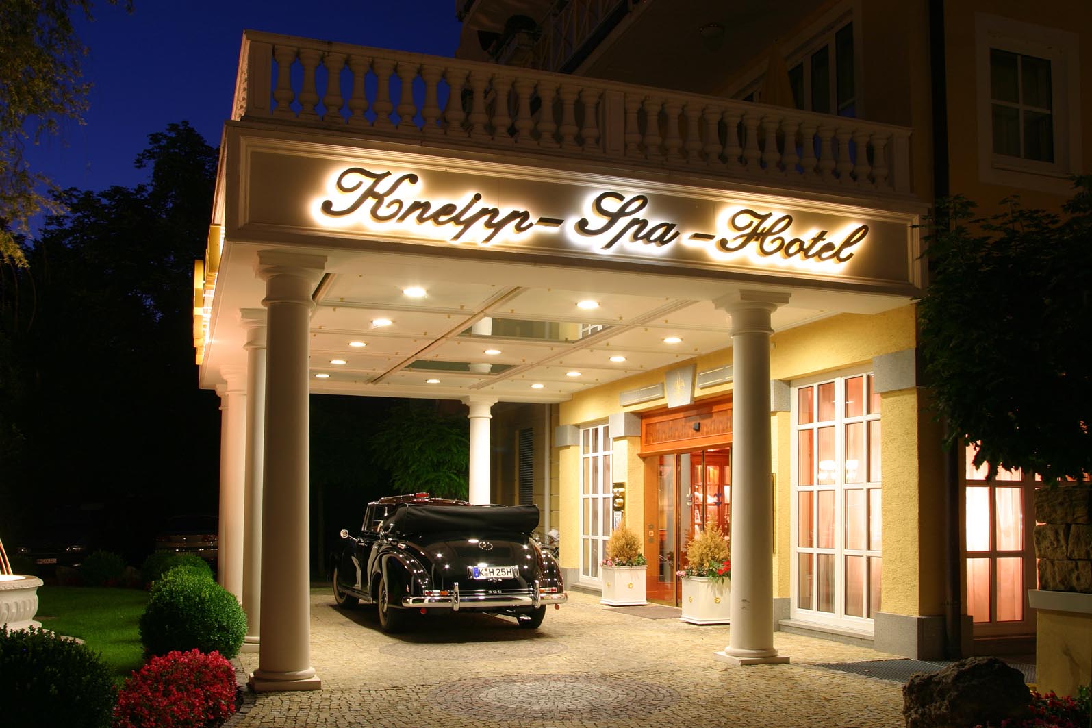Kurhotel Fontenay in Bad Wörishofen – Beleuchteter Hoteleingang am Abend mit Oldtimer | Wellnesshotel Allgäu