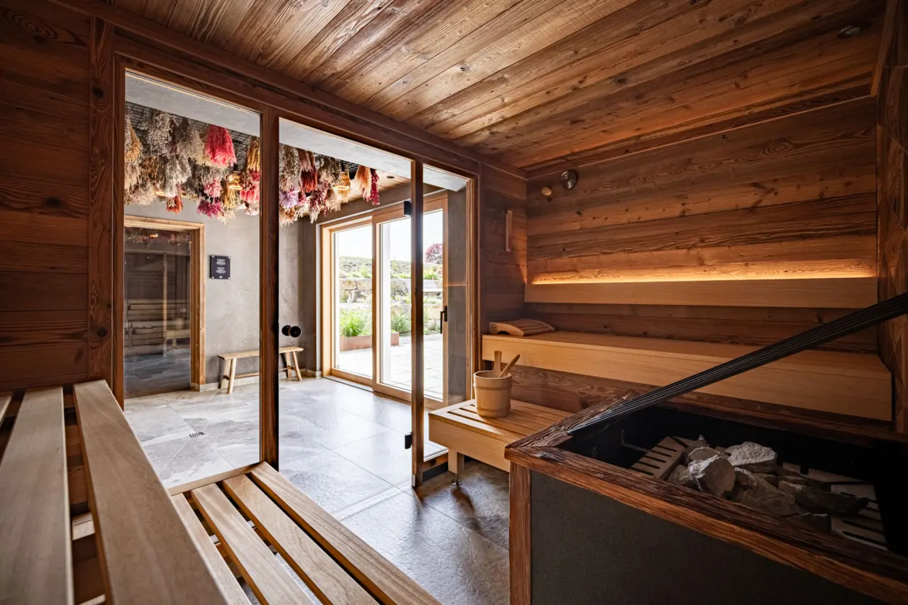 Gemütliche Holzsauna mit Blick ins Grüne und Trockenblumen-Dekoration im Wellnessbereich des Hotel Johanneshof.