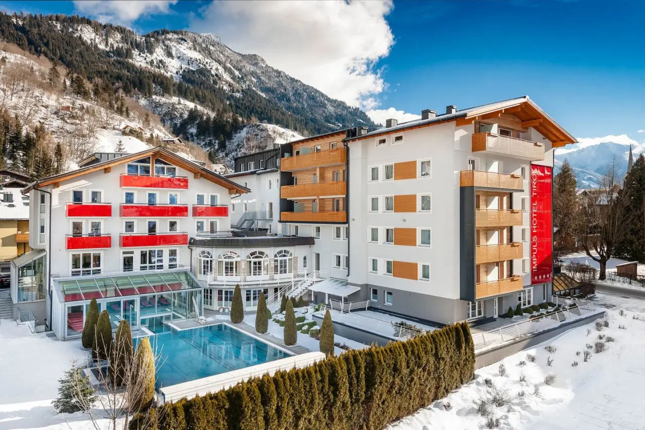 Impuls Hotel Tirol im Winter mit Aussenpool und verschneitem Bergpanorama. Modernes Wellnesshotel in den Alpen.