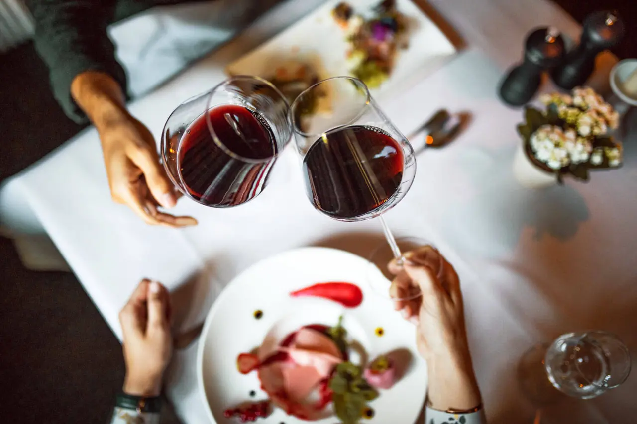 Romantischer Toast mit Rotwein und Gourmet-Dessert im eleganten Restaurant des Hotel Gotthard Lech.