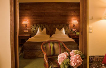 Gemütliches Doppelzimmer mit Holzwand und warmem Licht im Hotel Gotthard Lech.