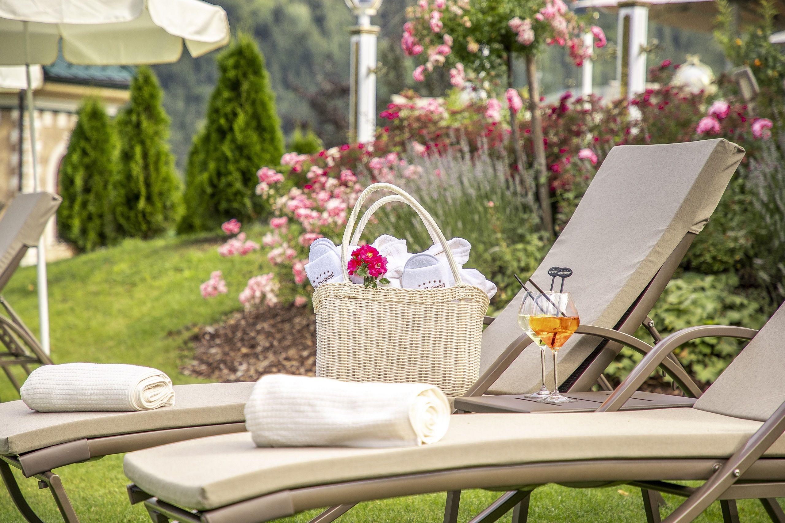 Hotel Der Lärchenhof in Erpfendorf – Liegestühle mit Handtüchern und Erfrischungsgetränk | Wellnesshotel Tirol