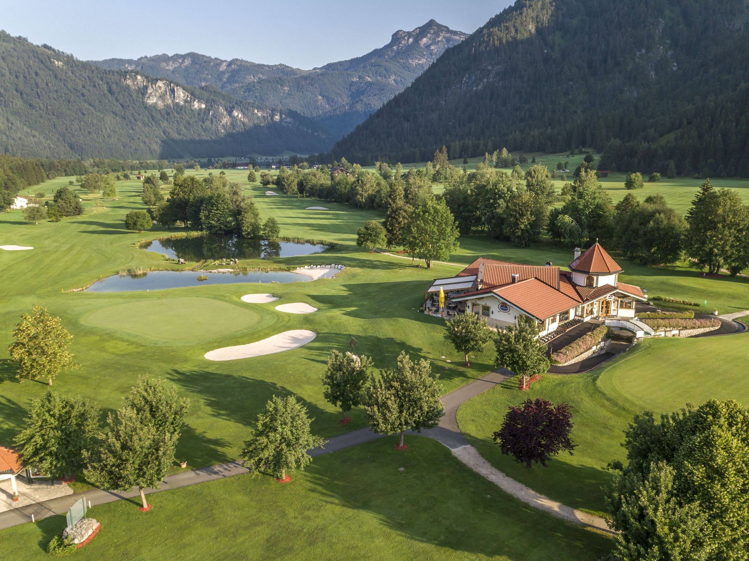Hotel Der Lärchenhof in Erpfendorf – Golfplatz mit Hotelgebäude und Bergpanorama | Wellnesshotel Tirol