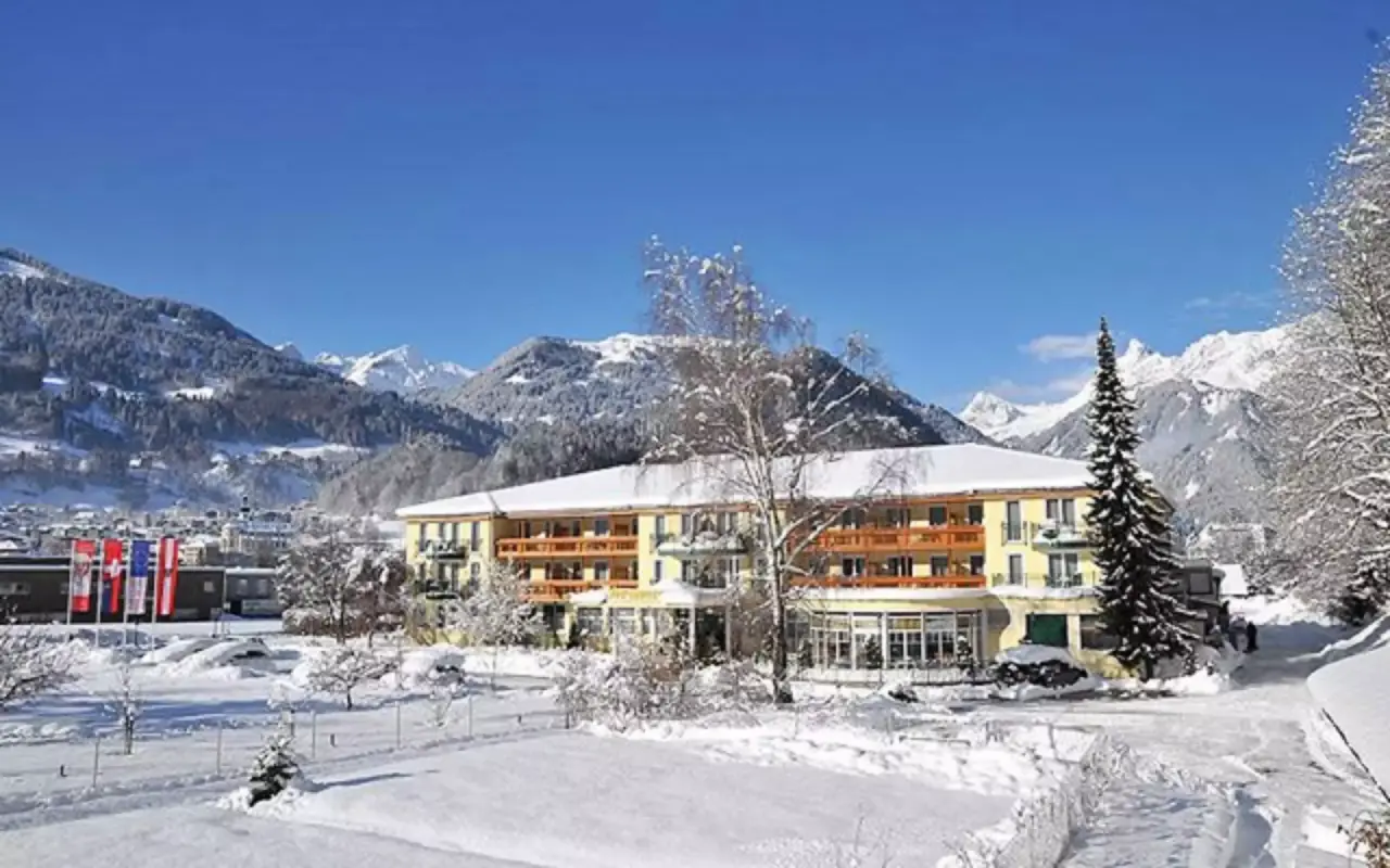 Winteransicht des Vitalquelle Montafon Hotels mit schneebedeckten Bergen und blauem Himmel im Montafon.