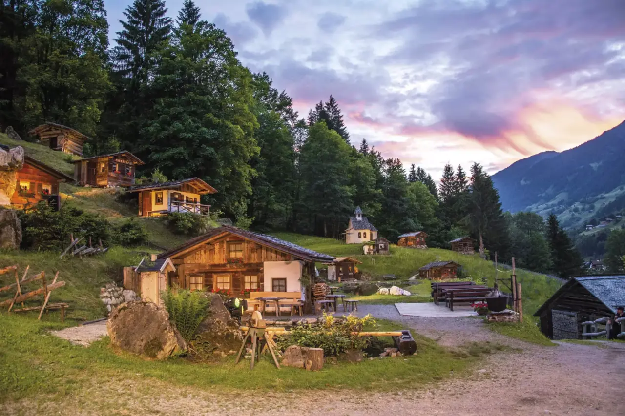Malerische Abendstimmung mit beleuchteten traditionellen Chalets und Bergpanorama im Vitalquelle Montafon.