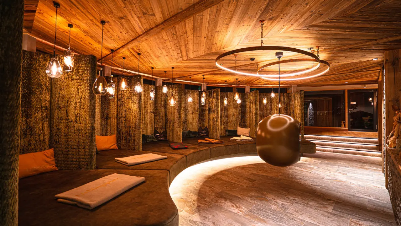 Gemütlicher Ruheraum im Wellnessbereich des Hotel Zum Ritter mit Holzdecke, bequemen Liegen und stimmungsvoller Beleuchtung.