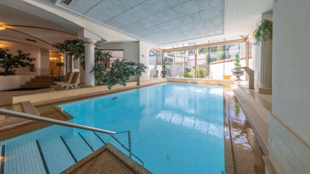 Heller Innenpool mit grosser Glasfront und Entspannungsbereich im Sport & Spa Hotel Strass.