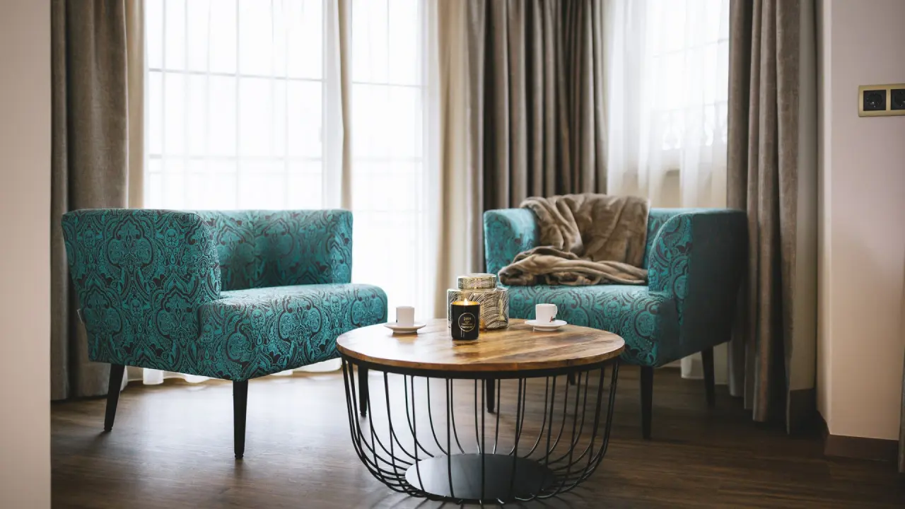 Gemütliche Sitzecke mit zwei türkisfarbenen Sesseln und Couchtisch im Sport & Spa Hotel Strass.