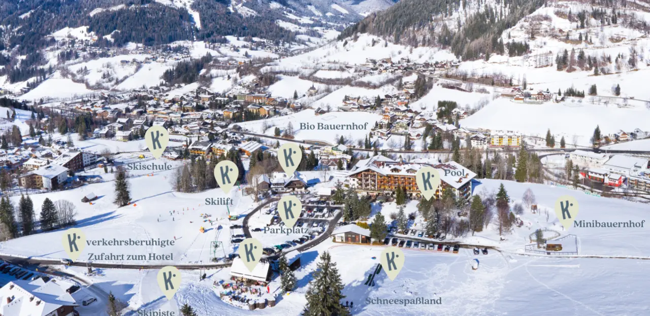Winterliches Luftbild vom Hotel Der Kirchheimerhof mit Skigebiet, Pisten, Skilift und umliegender Berglandschaft.