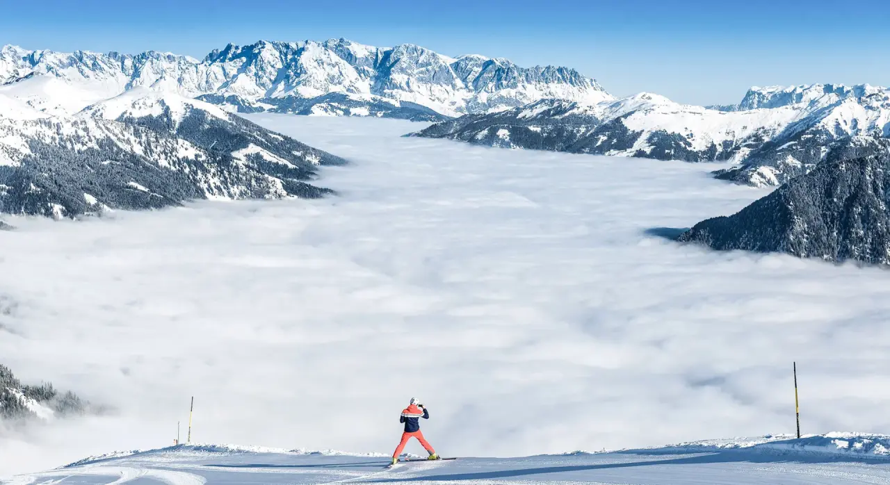 Skifahrer vor beeindruckendem Bergpanorama und Wolkenmeer in den Alpen, nahe dem EUROPÄISCHER HOF Aktivhotel & Spa.