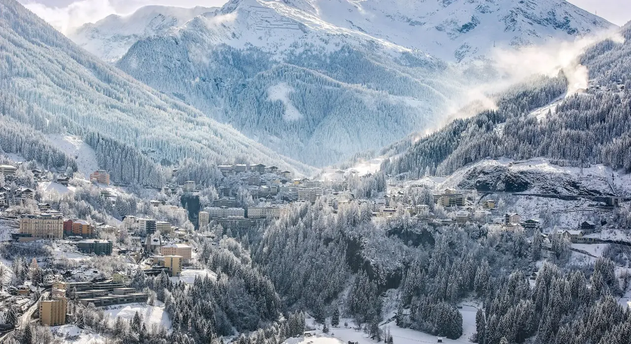 Panoramaansicht des EUROPÄISCHER HOF Aktivhotel & Spa in einer verschneiten Berglandschaft mit Wald und Dorf.