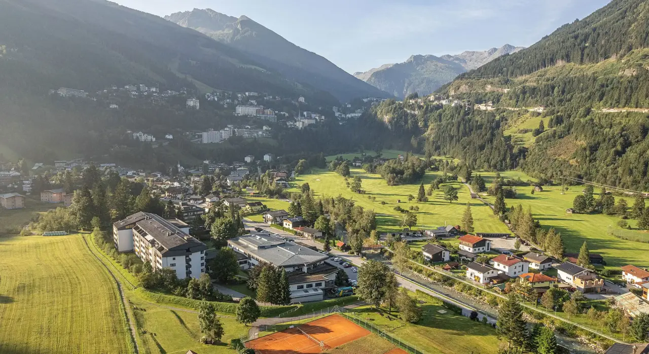 Luftaufnahme des EUROPÄISCHER HOF Aktivhotel & Spa im grünen Tal, umgeben von Bergen, Golfplatz und Tennisplätzen.