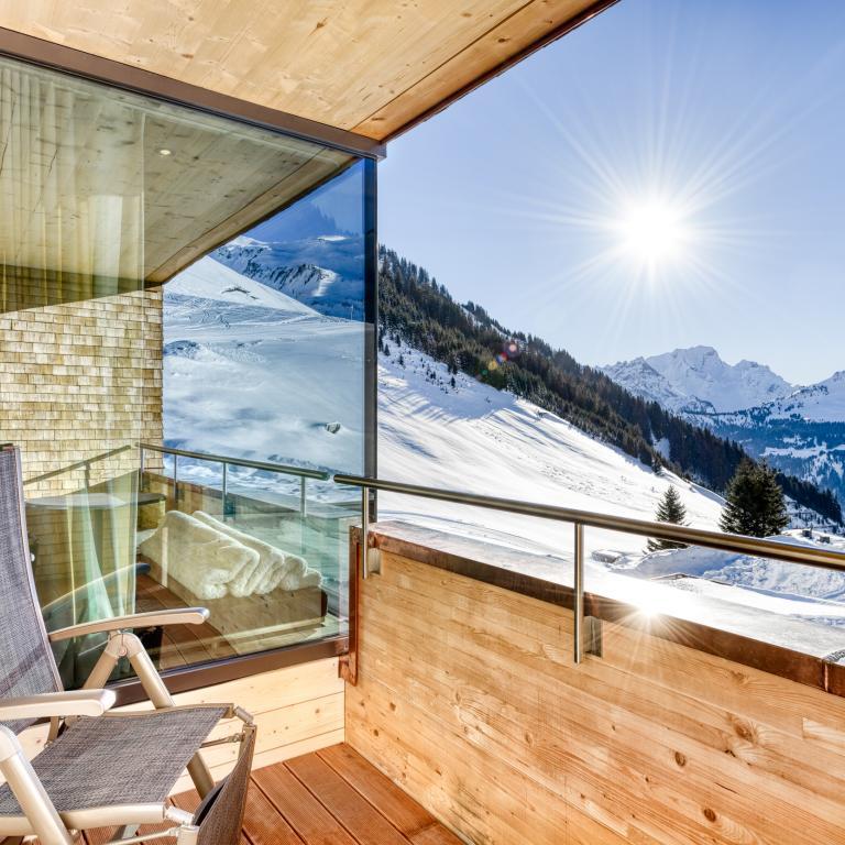 Alpenresort Walsertal in Fontanella – Balkon mit Panoramablick auf verschneite Berge | Wellnesshotel Vorarlberg